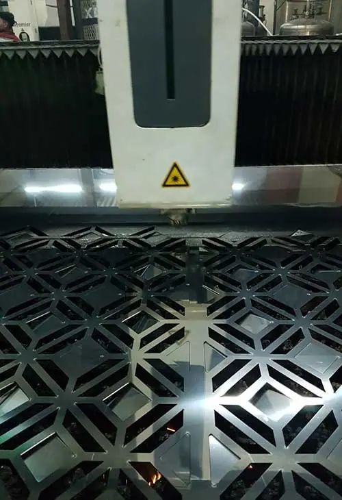 CNC laser cutting a decorative pattern in steel